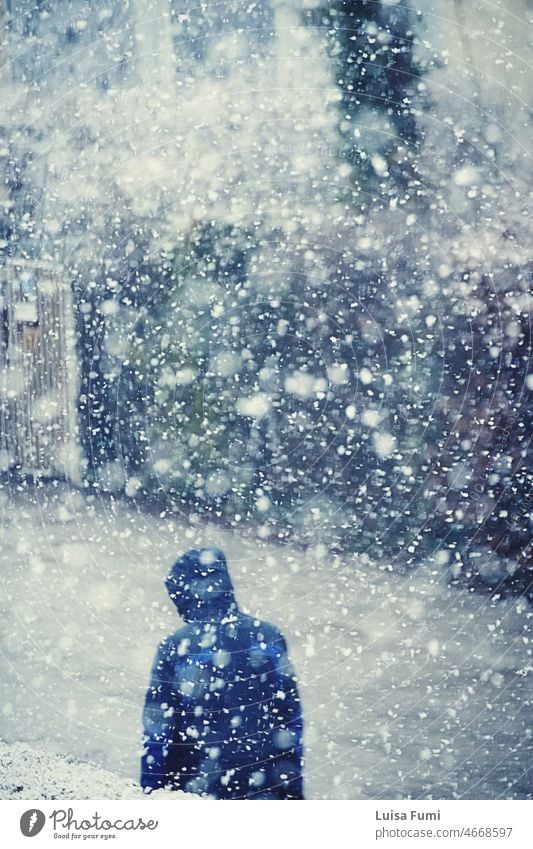 Person wearing a windbreaker walks under a heavy snowfall with large snowflakes man winter street nature snowstorm snowing pattern season weather walking