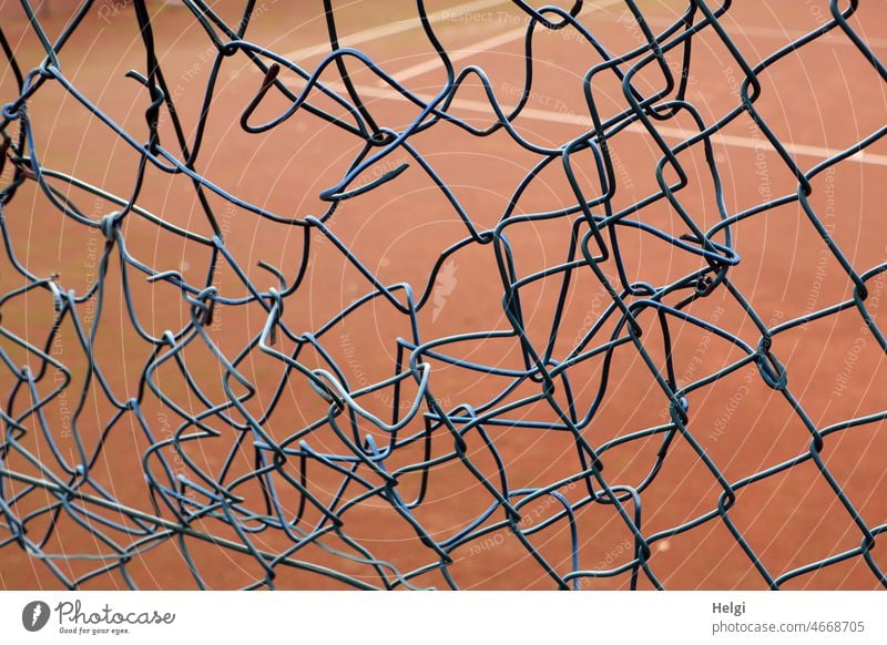 Patchwork - wire mesh fence with an amateurishly patched hole at the edge of a tennis court Fence Wire netting fence Hollow mended patchwork Safety demarcation