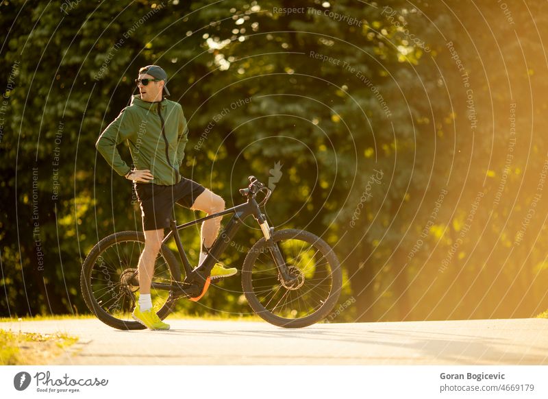Young man riding ebike in nature active battery bicycle biker biking black cyclist e-bike eco ecologic ecology electric electro energy engine equipment extreme