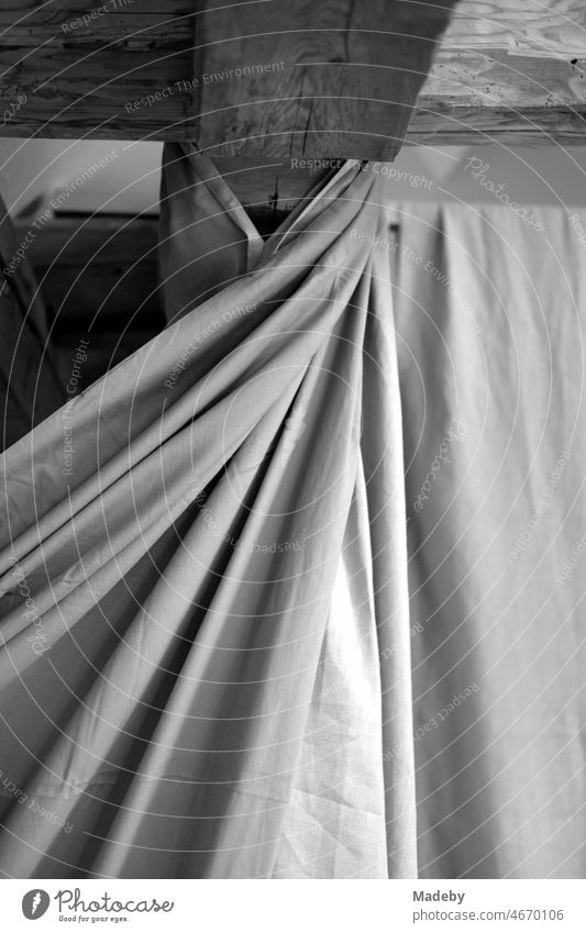 Old roof beams of a farmhouse with large drapery made of fabric with drapery in a designer apartment on a farm in Rudersau near Rottenbuch in the district of Weilheim-Schongau in the Pfaffenwinkel in Upper Bavaria, photographed in traditional black and white
