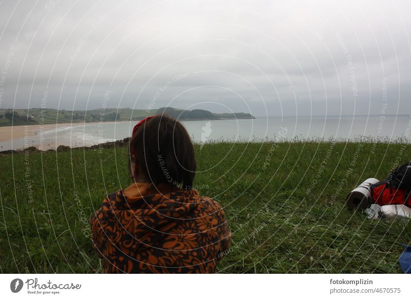 Woman looking at a sea bay Hiking outlook Ocean Bay Beach outdoor globetrotters travel camp camp wild Backpack Meadow Bad weather Clouds Sky Gloomy by oneself