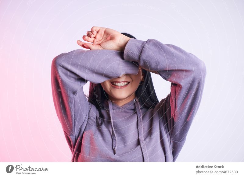 Anonymous woman covering eyes with arm cover eyes hide style casual modern cool gesture personality cover face dark hair female apparel individuality feminine