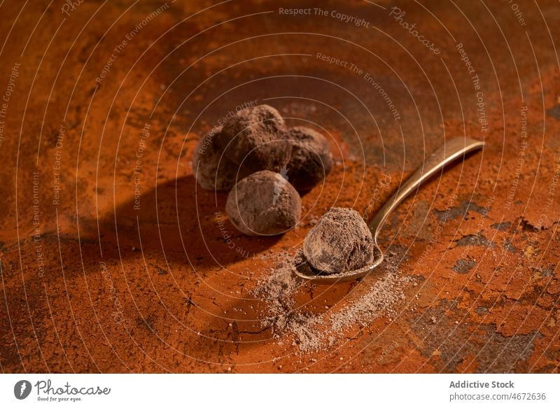 Spoon with truffles and cocoa powder on rusty surface chocolate dessert sweet delicious yummy tasty sugar spoon calorie table palatable gourmet treat appetizing
