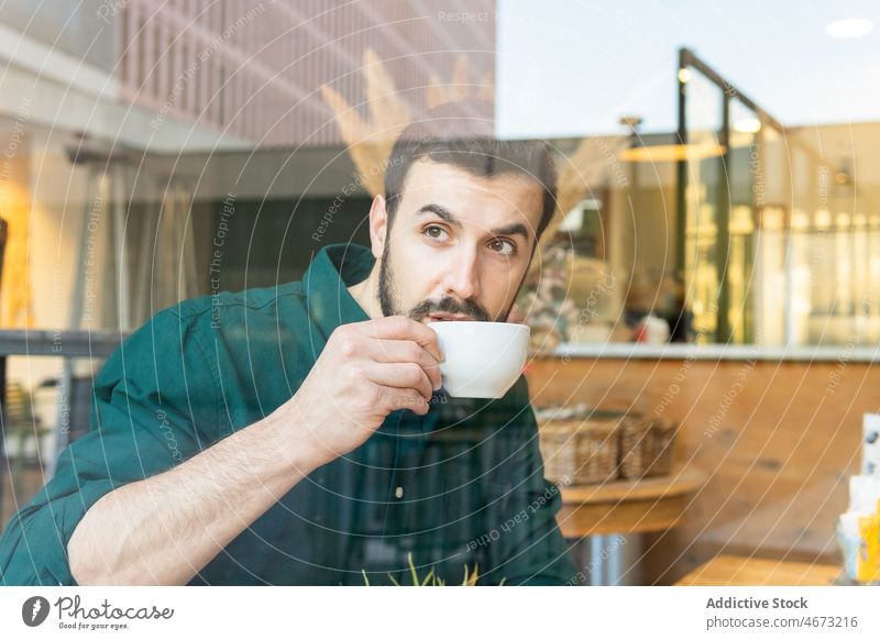 Man drinking coffee in cafe man hot drink cake dessert break lunch through windows entrepreneur cafeteria thoughtful table cup pensive delicious beverage food