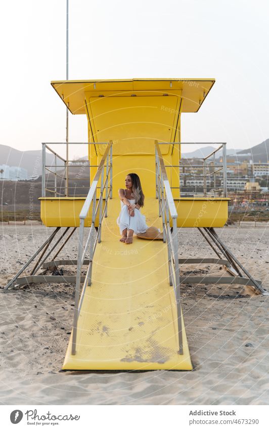 Happy woman resting near lifeguard tower summer happy seaside traveler beach holiday enjoy female young vacation cheerful relax smile carefree station cabin