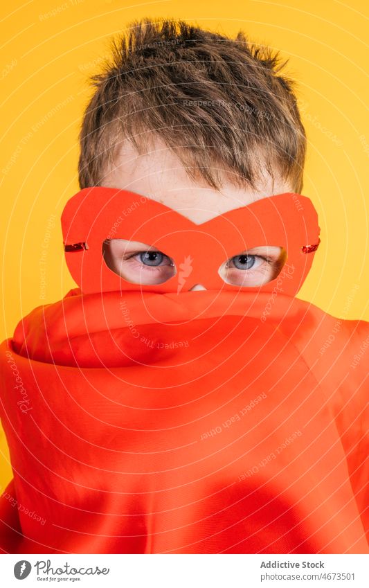 Boy in superhero mask and cape covering face boy child costume appearance cover face hide portrait studio power kid courage confident brave strong personality
