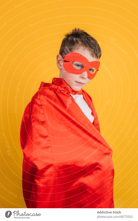 Boy in superhero mask and cape looking at camera in studio boy child costume appearance portrait power kid courage confident brave strong personality