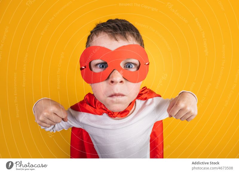 Boy in superhero outfit showing muscles boy child success victory achieve winner costume studio portrait kid courage brave power ambition mask bicep confident