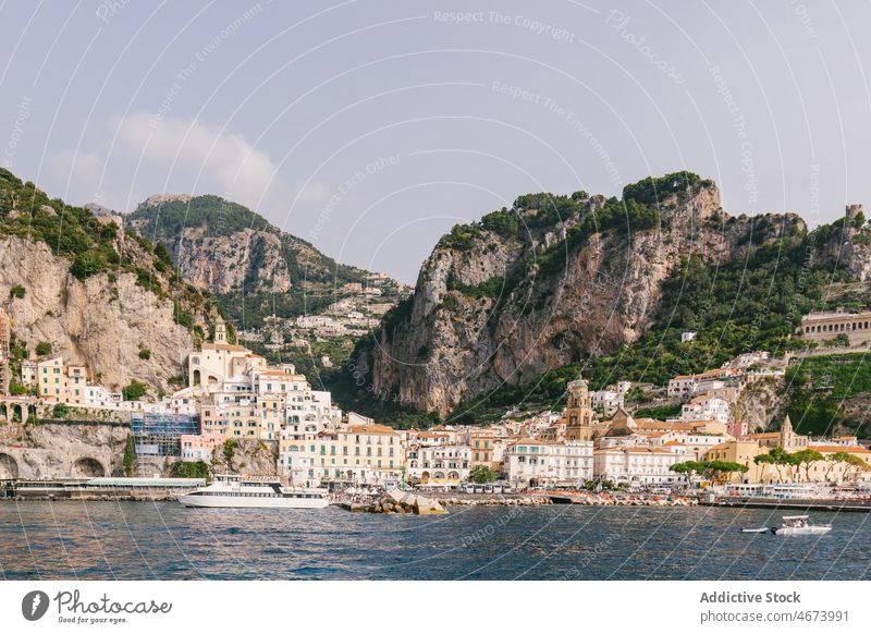 Motorboat floating near coast with buildings motorboat vessel town water bay sea mountain nature house waterfront italy environment aqua europe shore seaside