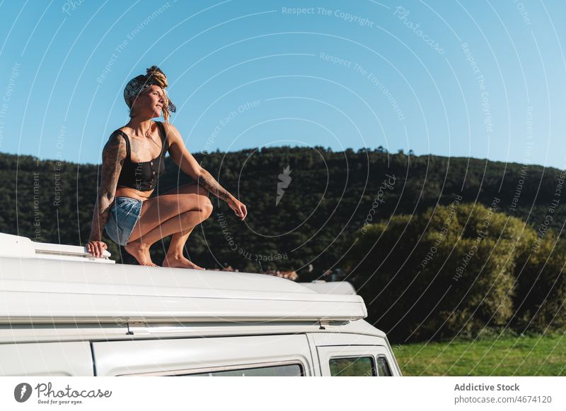 Hipster woman sitting on camping van rest recreation traveler camper hipster thoughtful road trip carefree hippie nature pensive trailer vehicle transport