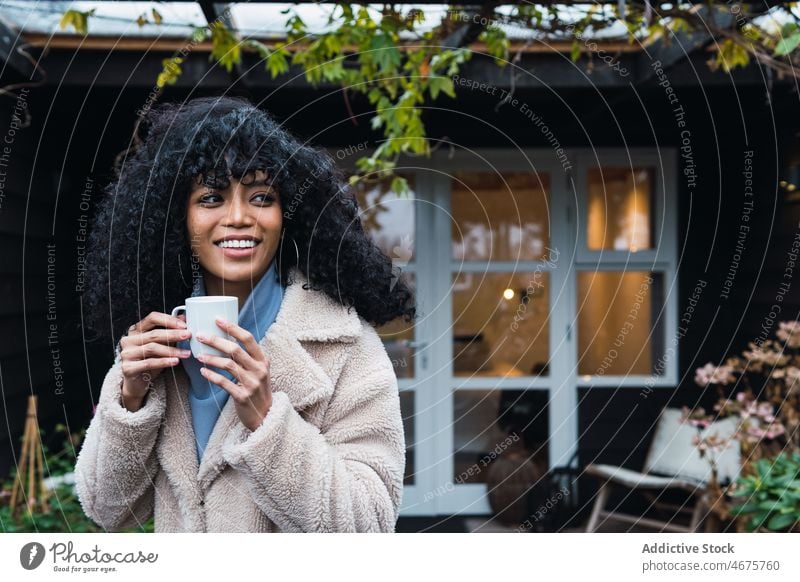 Smiling black woman with cup of coffee drink relax rest house home chill coffee break warm female african american woman mug hot drink positive beverage