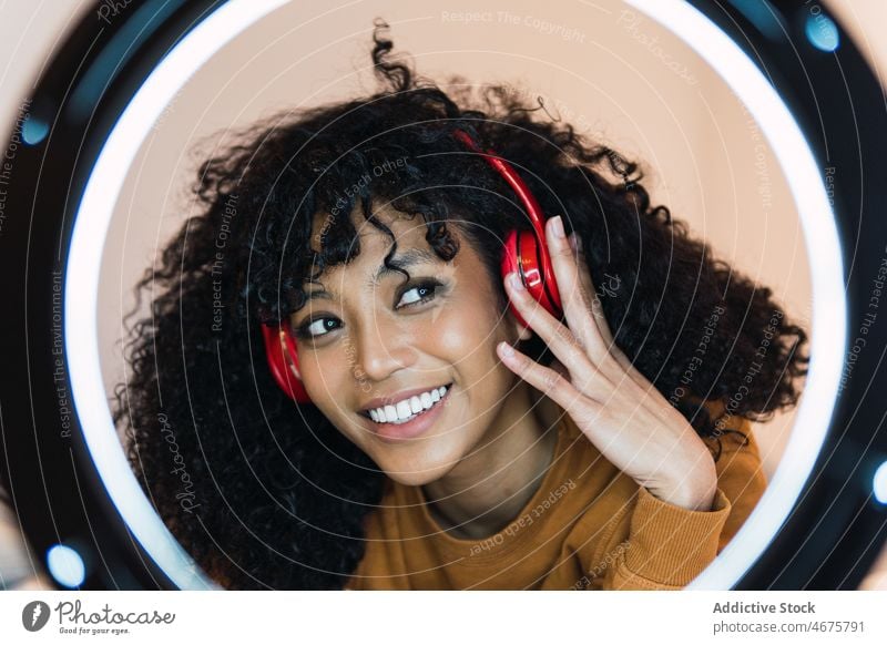 Smiling black woman listening to music in headphones using ring lamp meloman relax chill rest female african american woman young smile cheerful happy free time