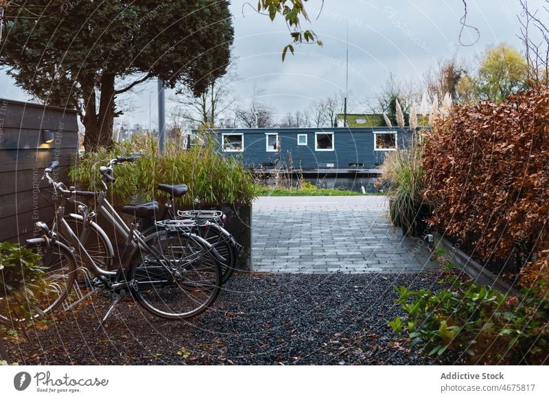 Bicycles parked near house in suburb bicycle yard city urban district vehicle bike autumn street transport architecture building town facade fall season