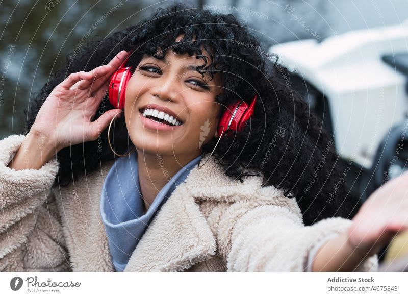 Cheerful black woman listening to music in headphones using walk city street urban weekend female african american relax leisure chill rest smile happy cheerful
