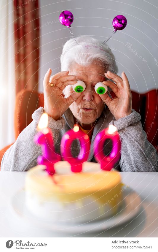 Funny elderly woman celebrating 100 birthday at home celebrate senior having fun party cake candle female aged hundredth holiday sweet happy funny festive event
