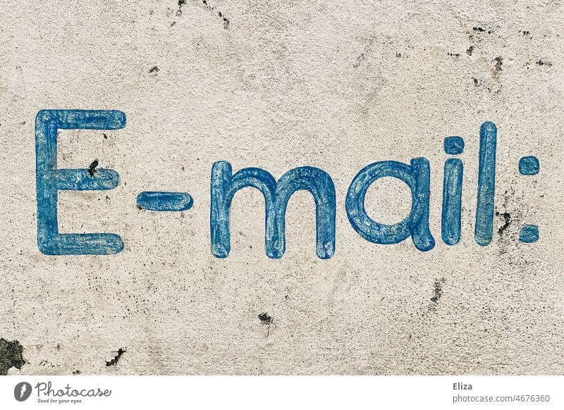 Written on a wall: E-mail email comunication Online authored customer service Contact Internet