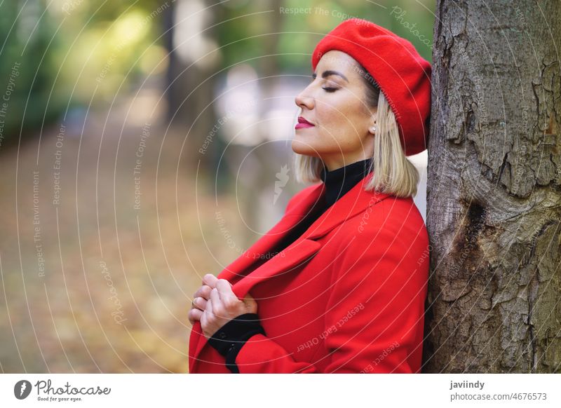 Dreamy woman near tree in a park dreamy style fashion design feminine outfit autumn apparel attire female appearance glad eyes closed plant charming trunk beret