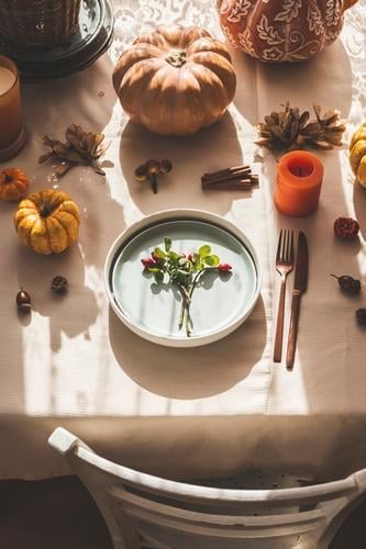 Autumn table setting with blue plate, pumpkins and decoration at kitchen table autumn chair sunlight vintage interior cozy time home october top view