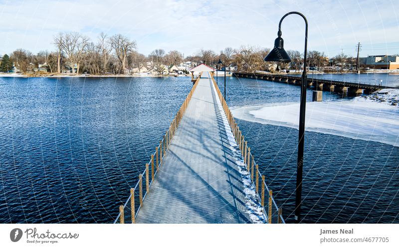 Public footbridge over icy waters surface landscape pier winter day sky neenah trestle clouds river city life public urban united states path travel wisconsin