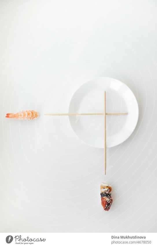 Sushi time - Concept photo of sushi with plate and chopsticks as a clock. Sushi clocks restaurant background. concept time for sushi - nigiri and unagi sushi japan food isolated on white with white plate and chopsticks imitating clocks.