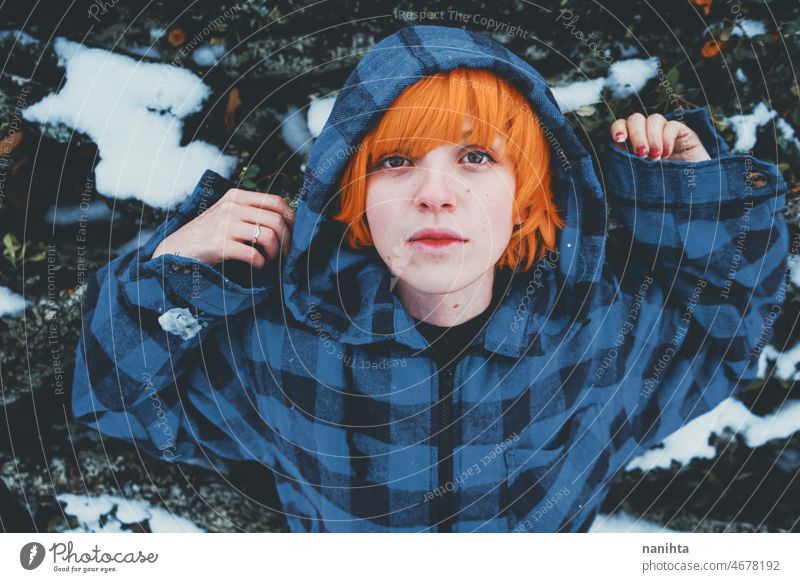 Redhead androgynous model in a winter scene people teen androgynious queer non-binary young youth cold hood hoodie redhead warm warmth thinkg alone wood