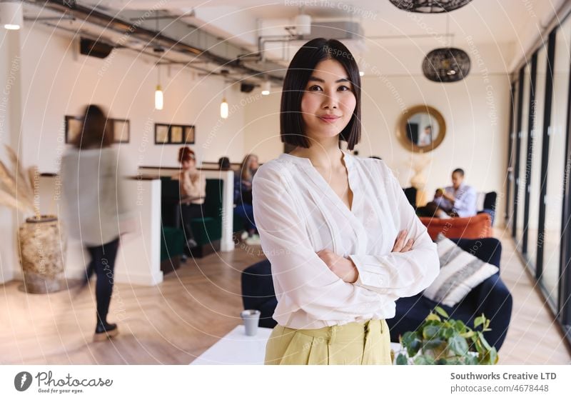 Portrait of confident mid adult Chinese woman looking at camera and smiling in coworking space international womens day leadership pride chinese asian