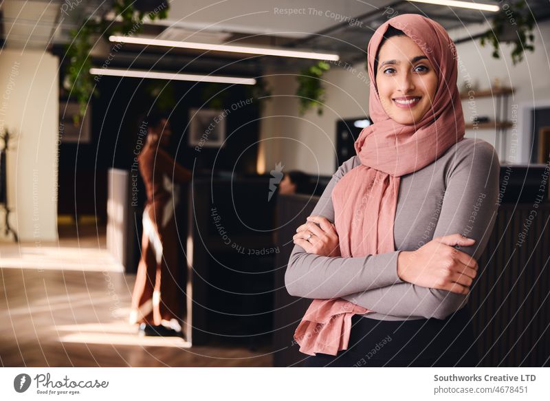 Portrait of confident young Middle Eastern woman smiling and looking at camera in coworking space middle eastern muslim business one hajib confidence leadership