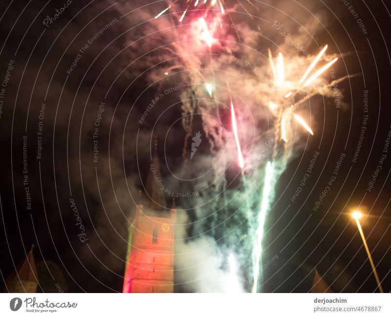 # 1100 # Fireworks - Everything is ignited, what flashes and cracks. The sky is darkened by the clouds of smoke.  The tower stands in the background and can hardly be seen.