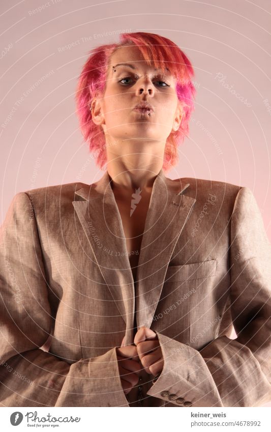 A young woman with pink hair dressed in a big jacket looks skeptically with pointed lips Woman Fashion Lips Skeptical dyed hair fashionable Men's fashion