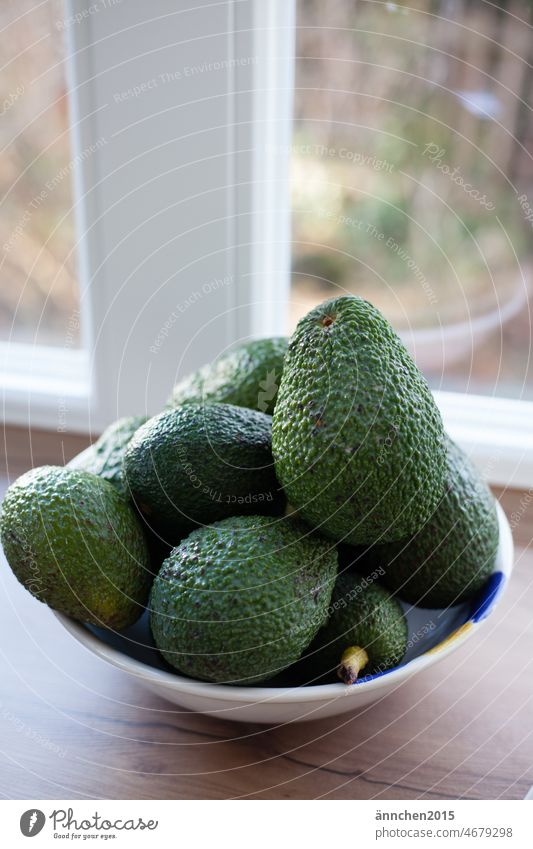 A bowl of green avocados stands in the kitchen by a white window Eating Avocado salubriously Food Delicious Vegetable Fresh Nutrition Healthy Vegetarian diet