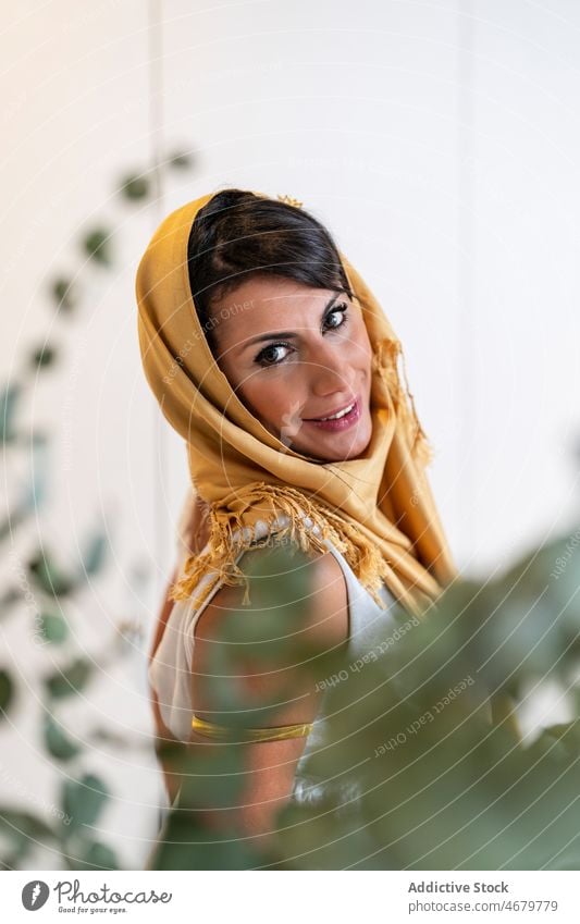 Beautiful Muslim woman looking at camera headscarf appearance tradition home smile room positive portrait brunette female adult makeup human face muslim ethnic