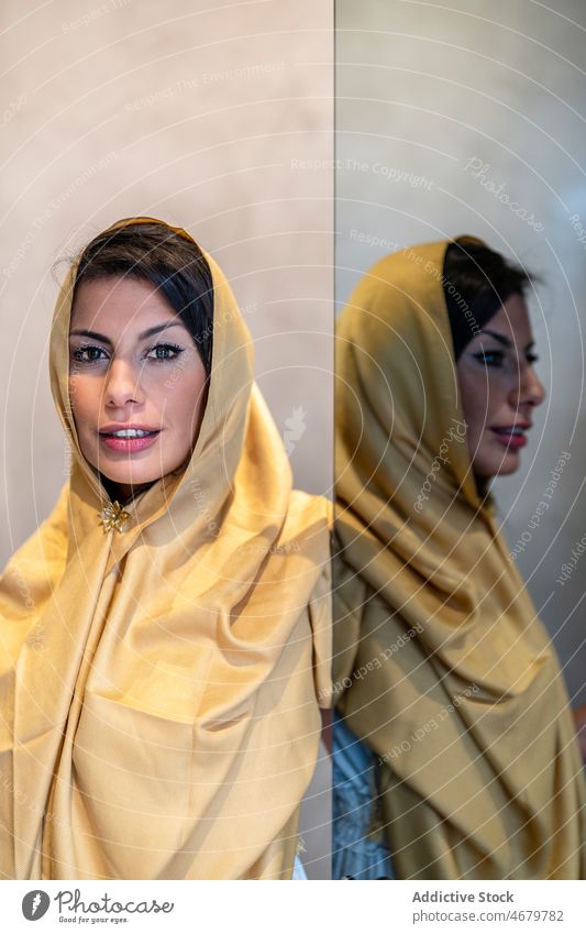 Muslim woman standing near mirror elegant home reflection tradition headscarf appearance feminine portrait female adult ethnic muslim islam personality daytime