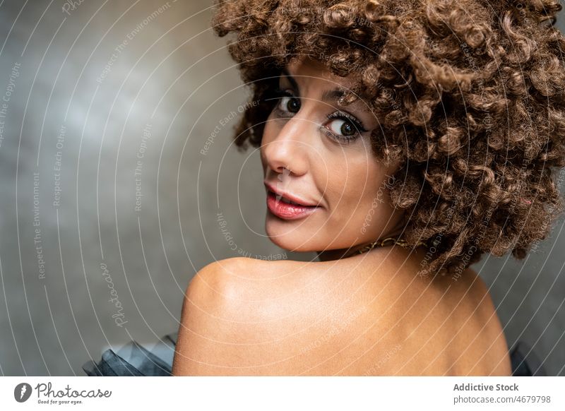 Positive woman with curly hair looking at camera style elegant makeup appearance portrait model female ethnic adult short hair individuality personality ponder