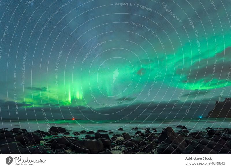Scenic landscape of aurora over rocky seashore in Norway polar nature seascape island aurora borealis ocean picturesque evening sky cloudy coast scenic lofoten