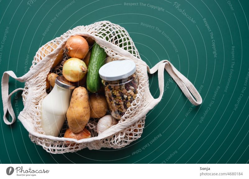 A shopping net filled with fresh vegetables, a milk bottle and legumes in a canning jar String bag Vegetable Fresh Raw Milk bottle Legume Shopping plan