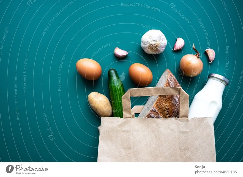 A paper shopping bag with vegetables, bread, eggs and a milk bottle on a green background Vegetable Fresh Shopping bag Paper Milk bottle Bread grocery shopping