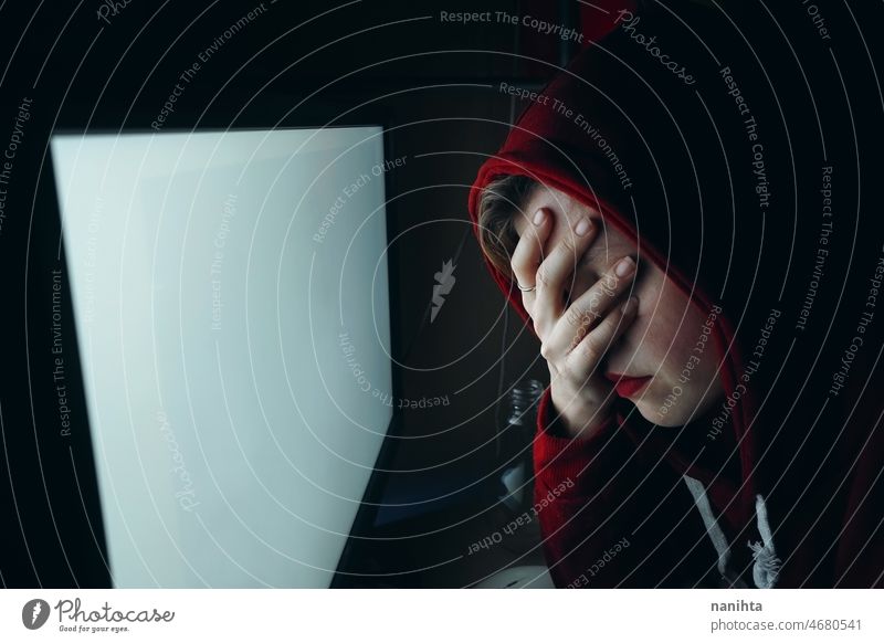 Young hacker woman in front of a white pc screen computer technology stress insomnia anxiety night work job wifi internet young youth teen student dark room
