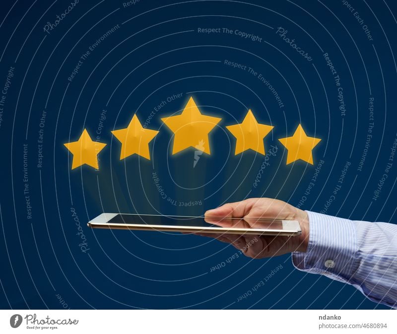 a female hand holds an electronic tablet and five yellow virtual stars above the screen. User rating of the application, service. Quality Rating classification