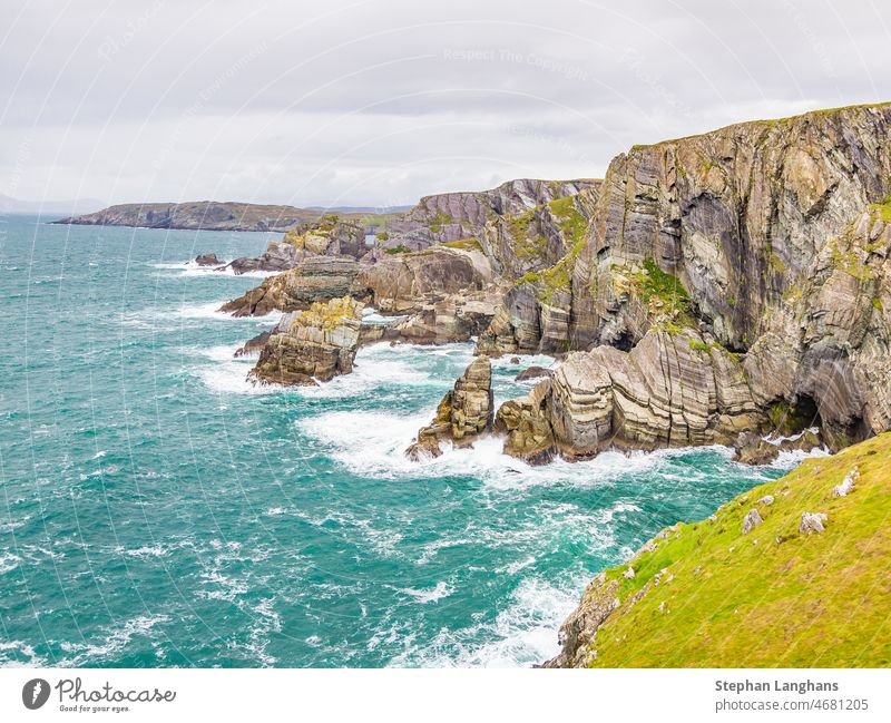 Rough cliff line at Mizen head lighthouse in southern west Ireland during daytime rocks cliffy rough wilderness danger dangerous nature force of nature