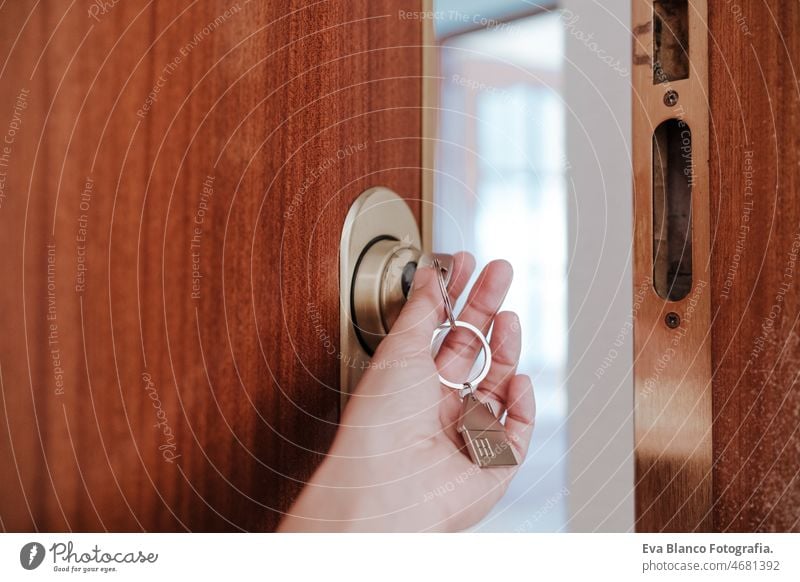 unrecognizable woman opening door home with keys and keyring with house shape.Home and lifestyle real state indoors door handle keyhole hardware neighborhood