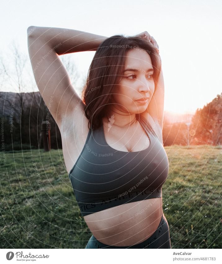 Portrait of a young woman stretching arms during a training session to lose weight on a sunset. Training new sports concept. person athlete exercise fitness