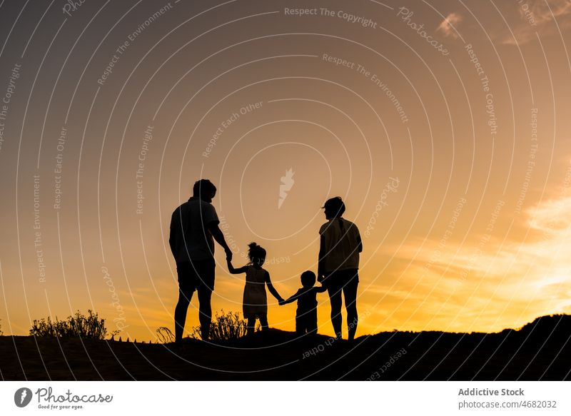 Anonymous family with kids walking on nature children silhouette sibling parenthood mount sunset childhood relationship love summer boy happy mother father