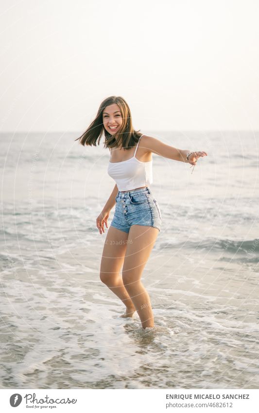 Happy woman smiling on the shore of the beach arms freedom peaceful sunshine calm person pretty summertime sunlight carefree content escape eyes feeling getaway