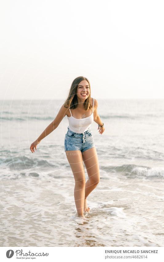 Happy woman smiling on the shore of the beach arms freedom peaceful sunshine calm person pretty summertime sunlight carefree content escape eyes feeling getaway