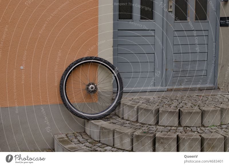 Bicycle tire with blue door and salmon color facade salmon-coloured Tire Cycling Means of transport Transport Mobility Bicycle tyre Wheel Spokes Repair