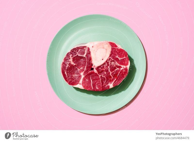 Raw beef steak above view on a pink background. barbeque bbq big bone bright butcher cattle chop close-up color cow cuisine cut out dinner fillet flat lay food