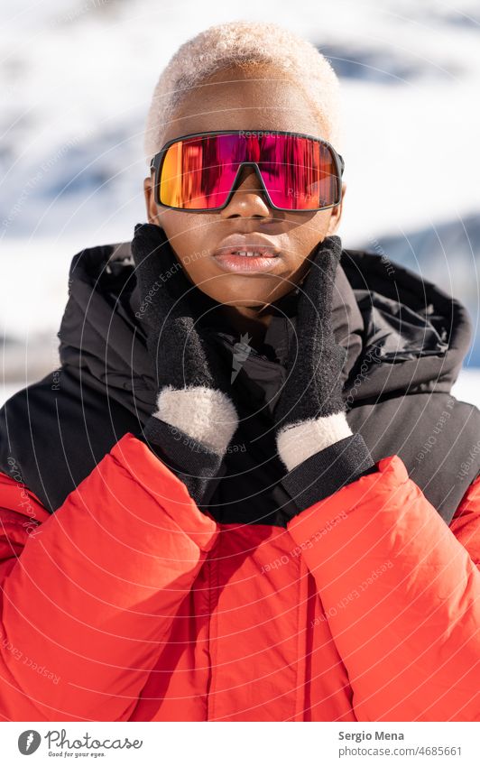 African American woman wearing goggles standing in snowy mountain during winter snow goggles one person afro american blonde hair young lifestyle enjoy face