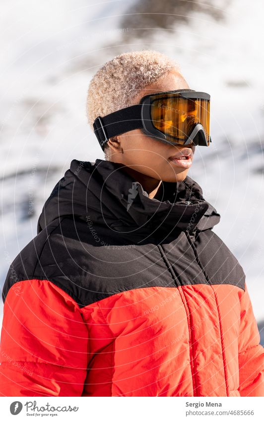 African American woman wearing goggles standing in snowy mountain during winter snow goggles one person afro american blonde hair young lifestyle enjoy face