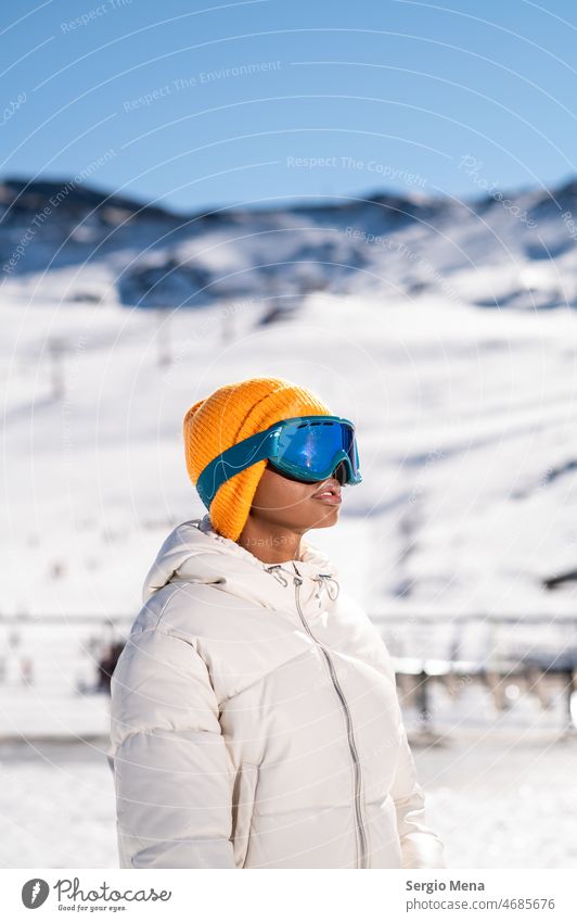 African American woman with goggles standing in a snowy mountain in winter snow-covered mountain Skiing goggles Winter one person Woman Afro blonde hair