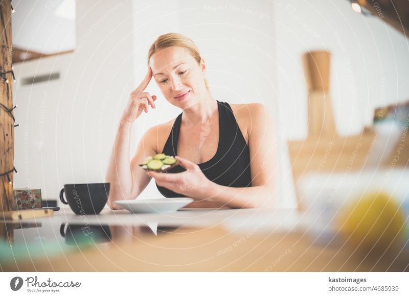 Beautiful sporty fit young pregnant woman having a healthy snack in home kitchen. Healty lifestyle concept meal preparing diet cooking fresh food female